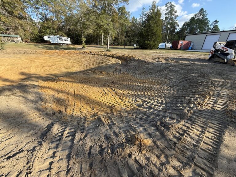 Newly shaped and compacted pond basin after excavation work on a residential property in Pensacola.